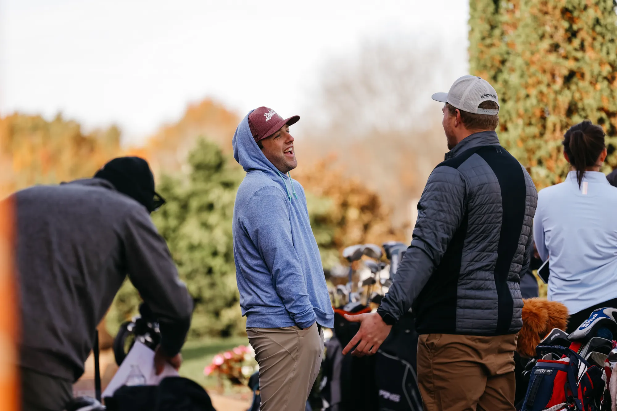 Members laughing by their golf bags